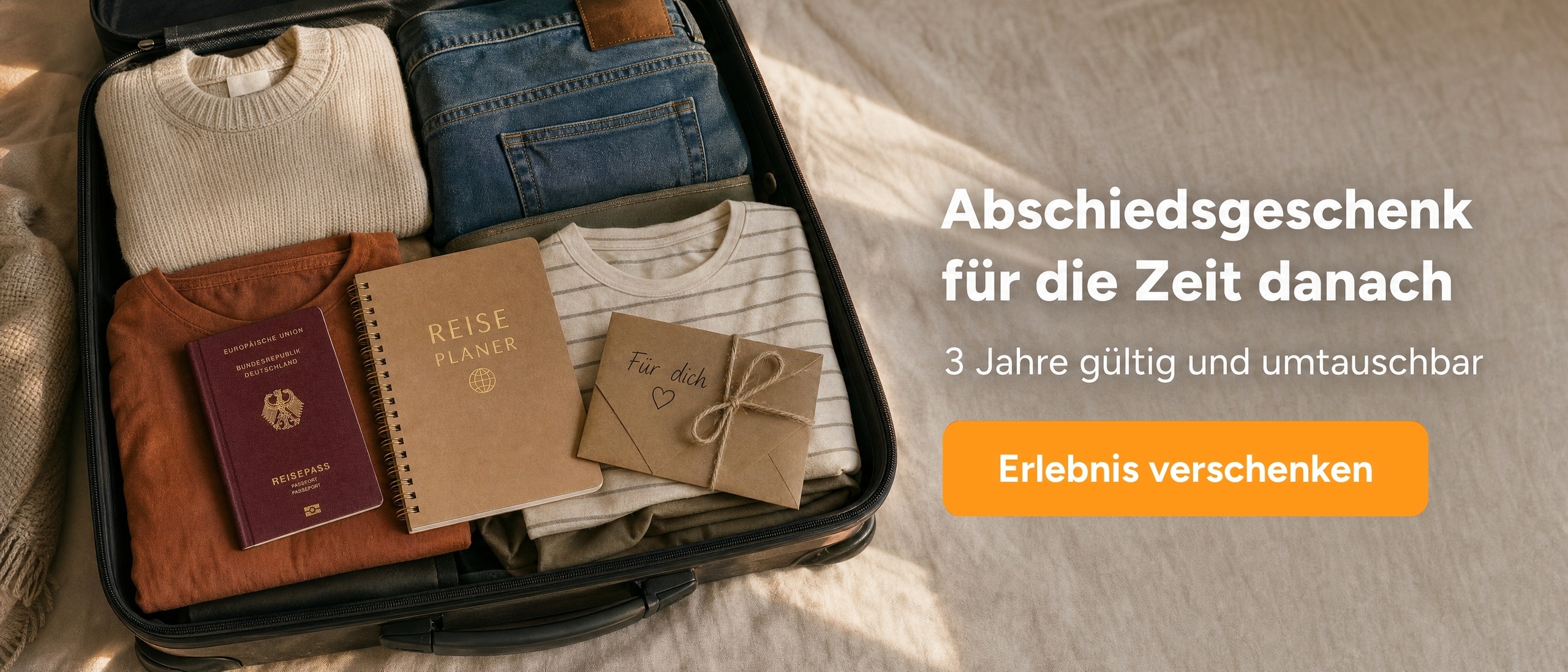 Gepackter offener Koffer von oben mit Kleidung, Reisepass und Geschenkumschlag mit dem Schriftzug &bdquo;Abschiedsgeschenk f&uuml;r die Zeit danach&ldquo;.